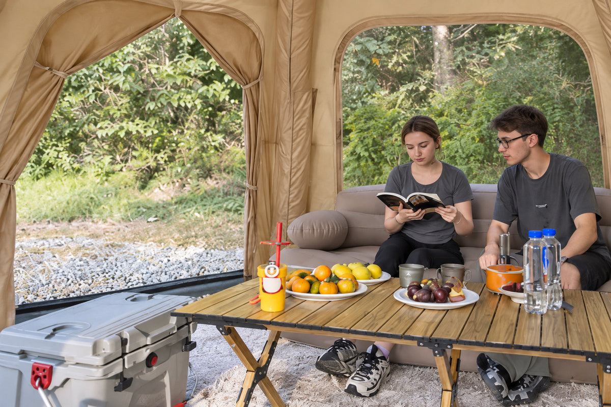 Olive green Dome tent interior with a couple reading beside a camping table.