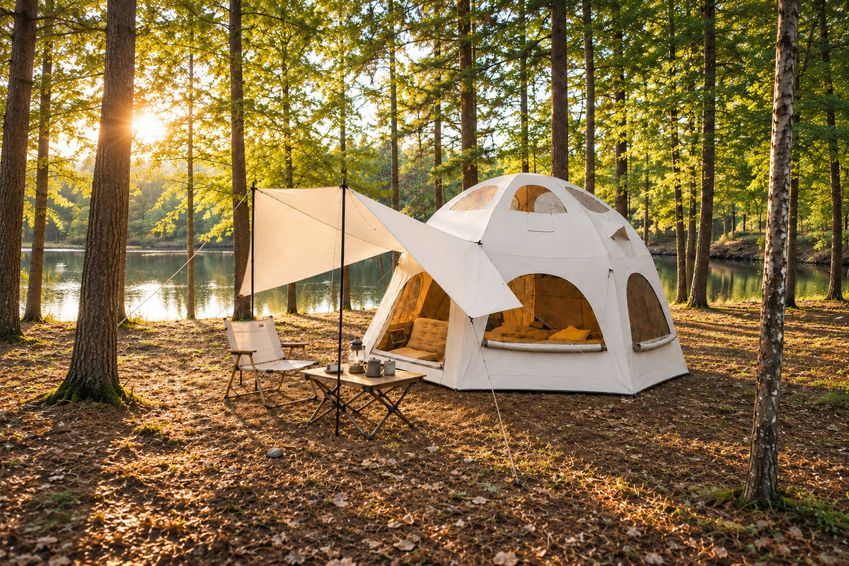 Khaki Dome tent with an extended side awning and seating at a woodland campsite.