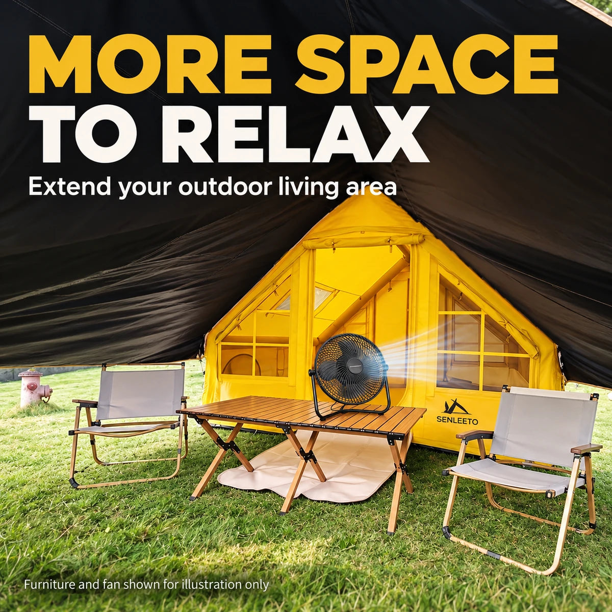 Outdoor seating area beneath the yellow tent canopy, with camping chairs, a table and a fan.