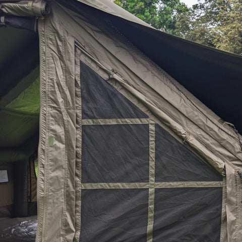 Mesh panels beside the army green tent entrance.