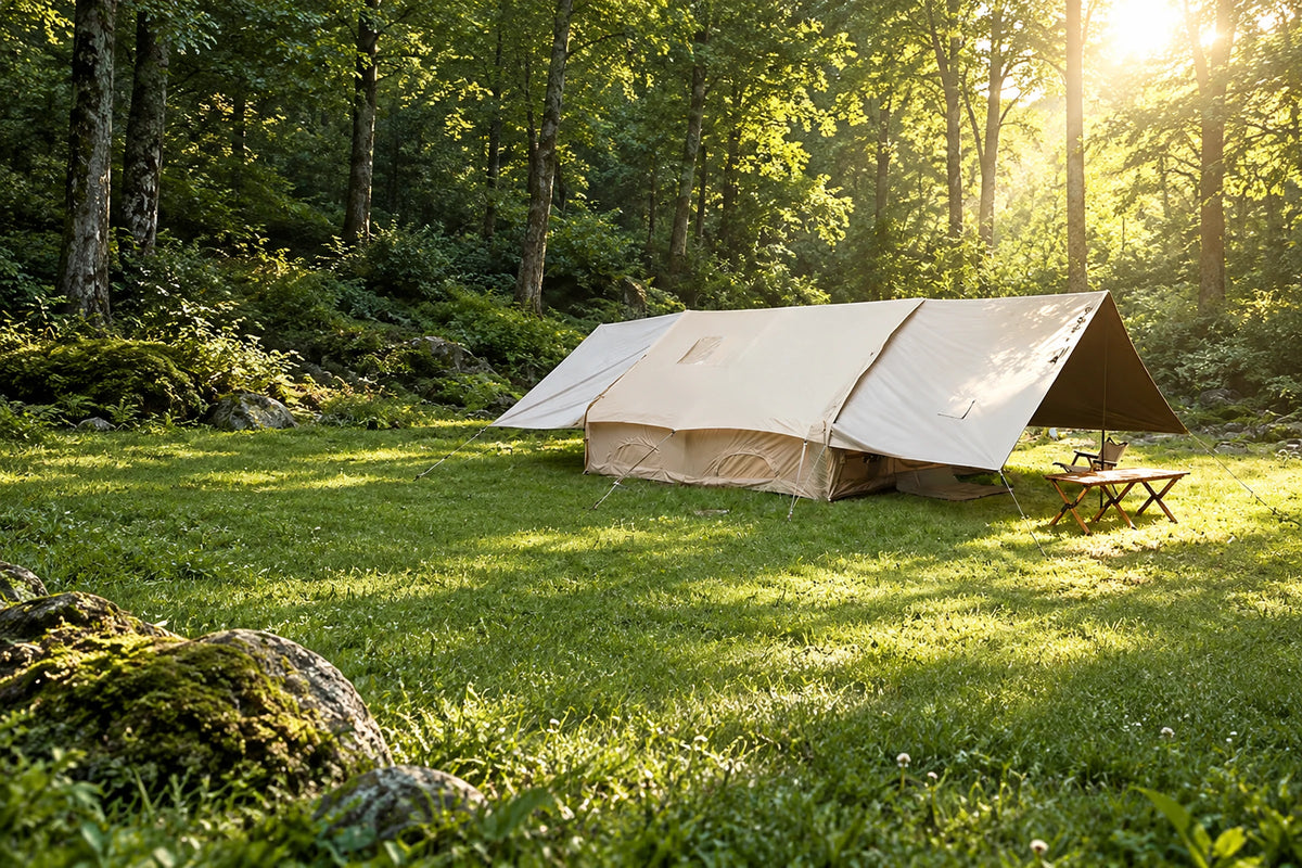Khaki Cabin tent with both end extensions raised in a forest clearing