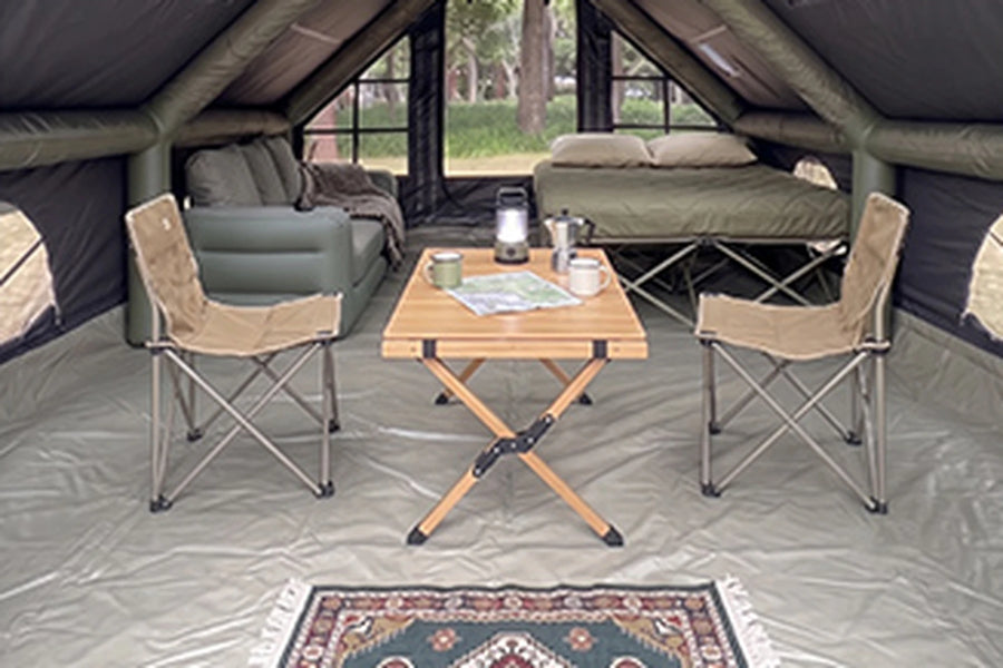 Table, chairs and bed inside the black Cabin tent