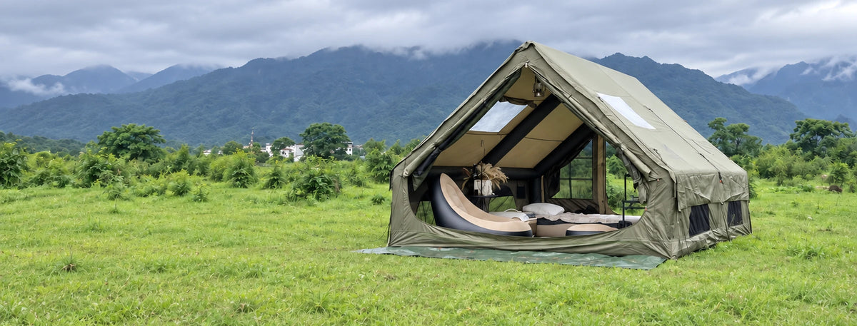Army green Cabin 13 x 10 tent pitched on grass with mountains in the background