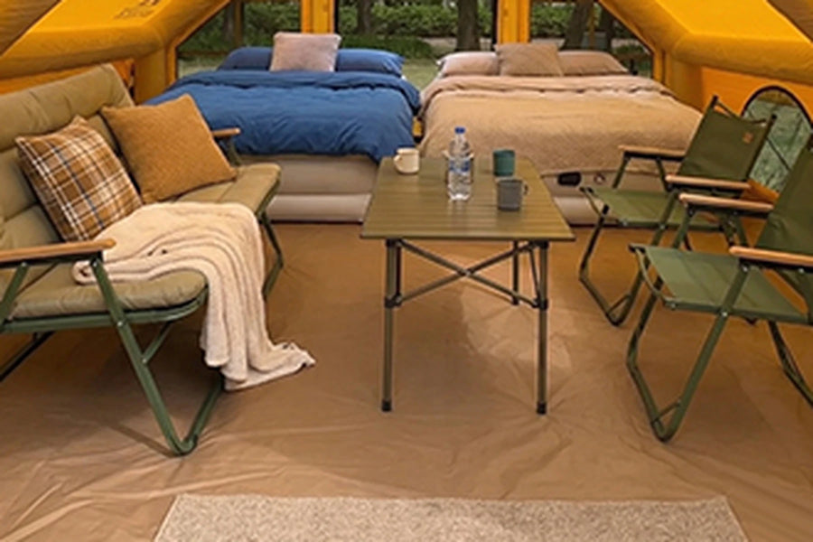 Two beds and seating inside the yellow Cabin tent
