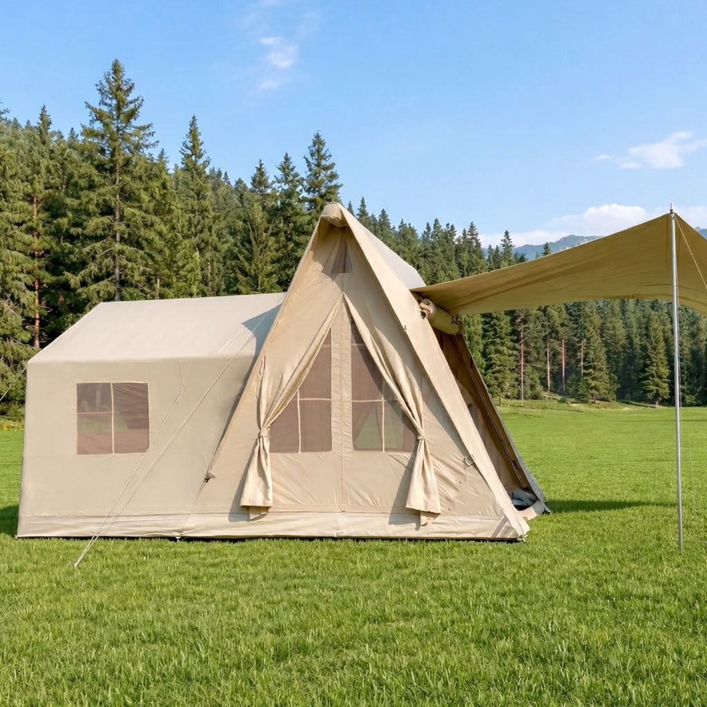 Beige canvas A-Frame tent with extended awning for luxury glamping on a grassy field.