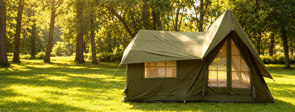 Green A-Frame tent in a sunlit woodland camp.