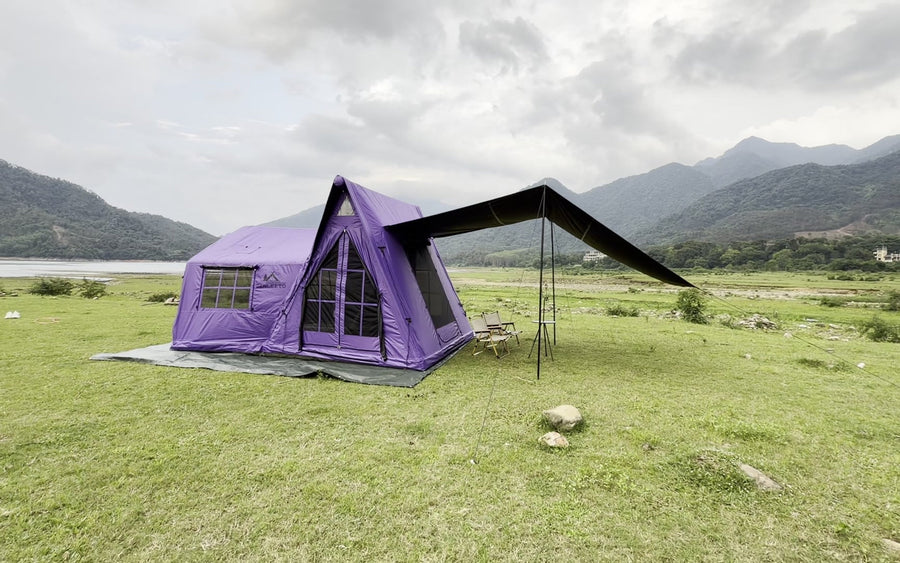 Purple A-Frame tent with its side awning beside a lake.