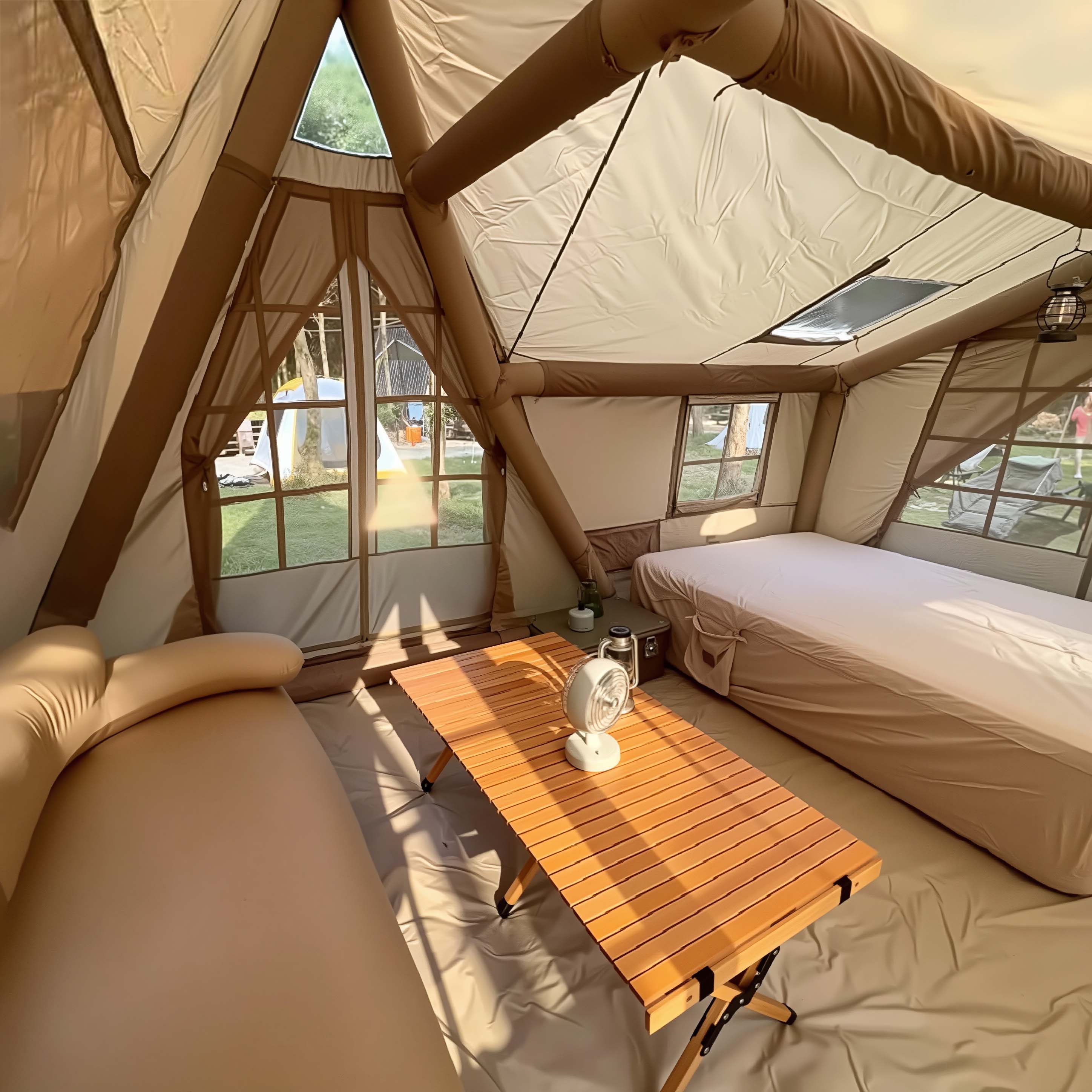 Interior of Senleeto inflatable glamping tent. Setup with bed, sofa, and table shows massive space for camping.